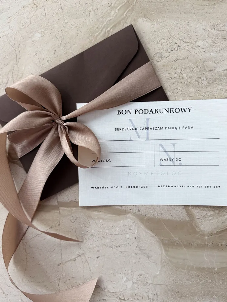 Bon podarunkowy w kopercie przewiązanej satynową wstążką